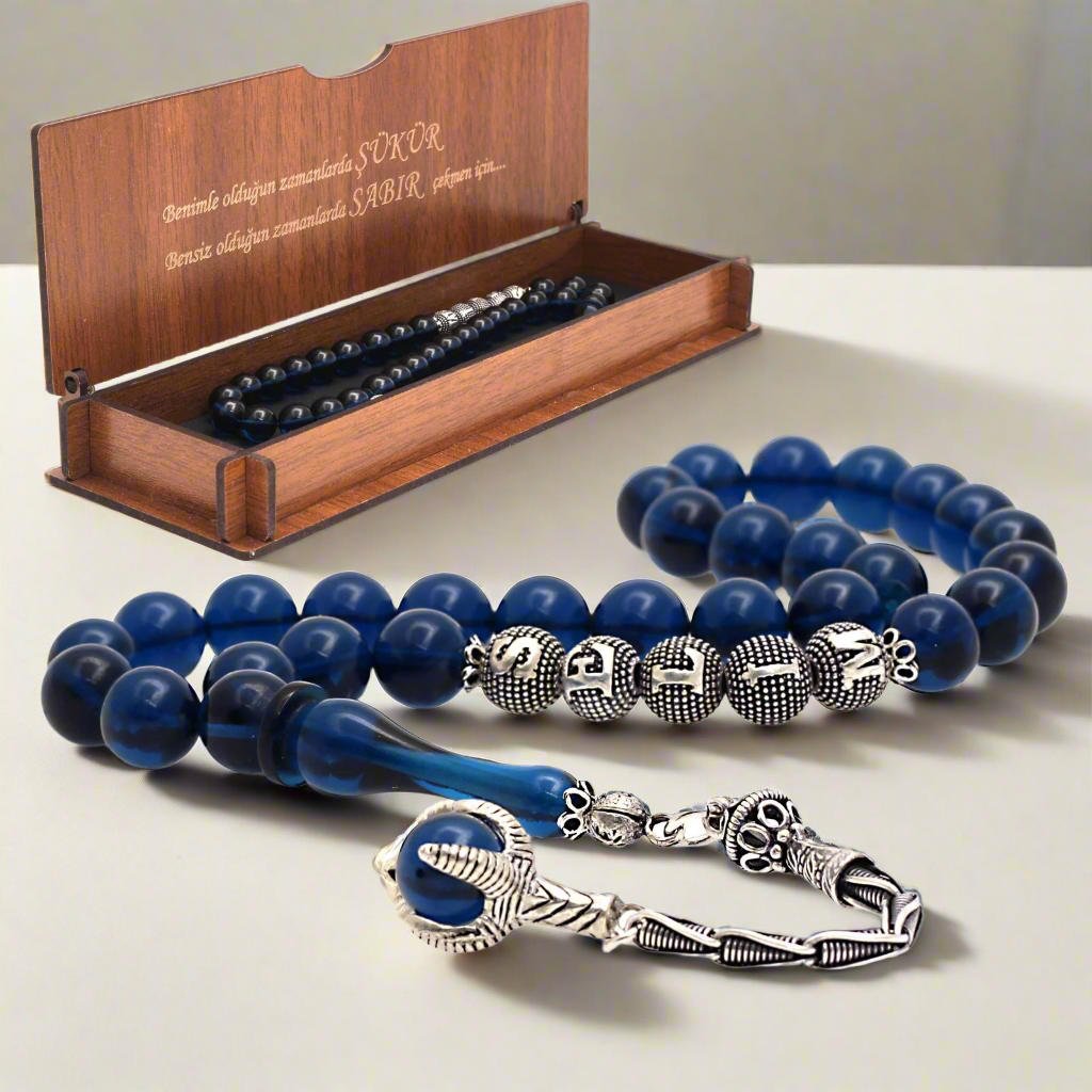 Navy blue squeezing amber rosary and note written in a written box